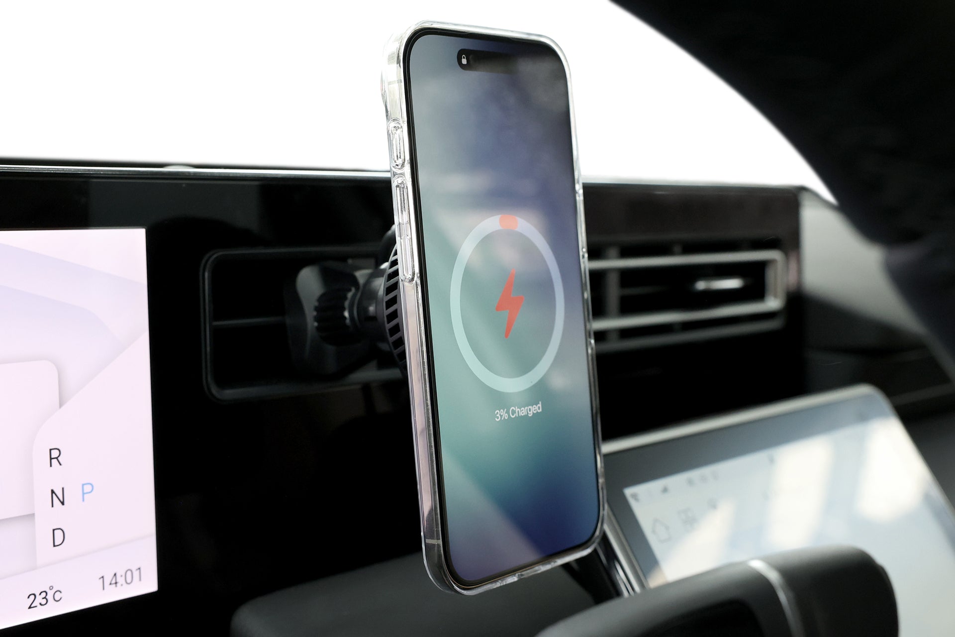 使用 JOWUA Taiwan Qi2 製冷出風口車架 (MagSafe 款)，將充電螢幕的智慧型手機安裝在汽車出風口上，背景可見數位螢幕和控制面板。.