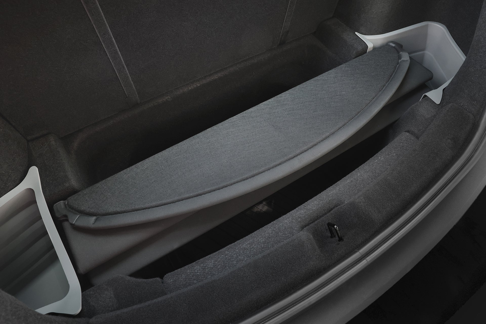 JOWUA Taiwan 電墊專案【Model Y 煥新版｜交車禮包】後備箱內部特寫，灰色布料貨箱蓋與後行李廂儲物盒，側板可見。.