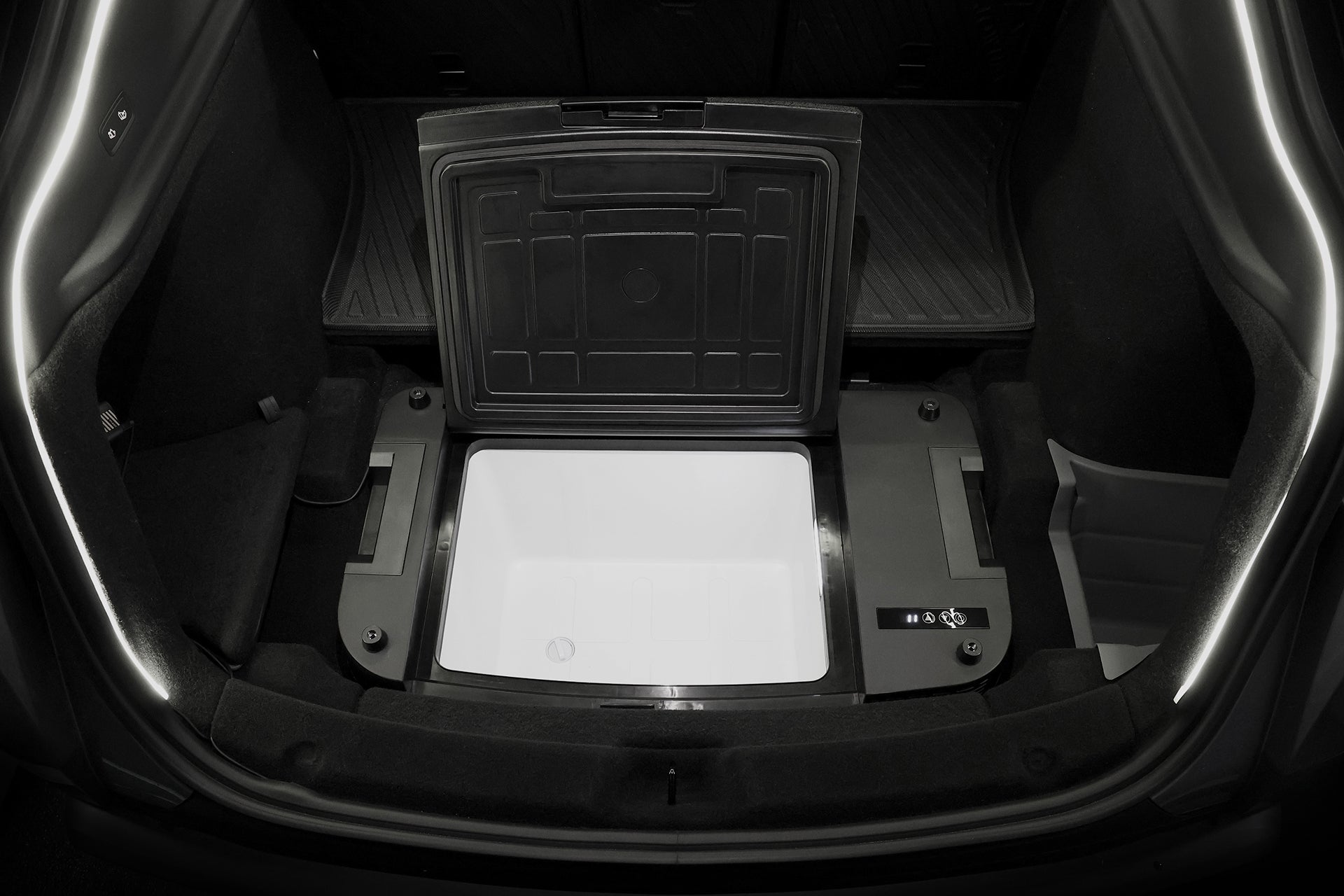 打開汽車後備箱，可以看到一個內建蓋子的夾層，裡面是 JOWUA 台灣 Type-C 車用行動冰箱 (Model Y全車系)。車廂右側的控制面板上有按鈕和數位顯示器。.