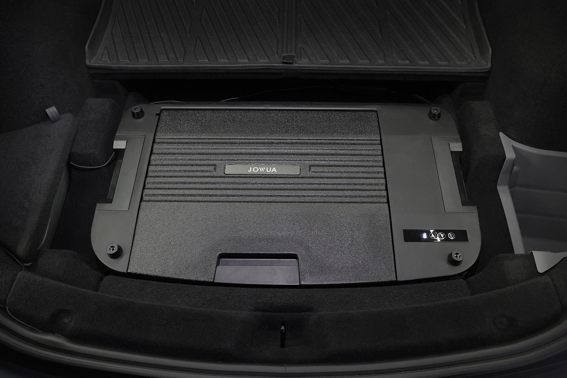 汽車後備箱的特寫顯示，黑色長方形的 JOWUA Taiwan 收納盒與 Type-C 車用行動冰箱 (Model Y 全車系) 相鄰，兩者都整齊地放置在深色的車內襯裡與地墊上。.