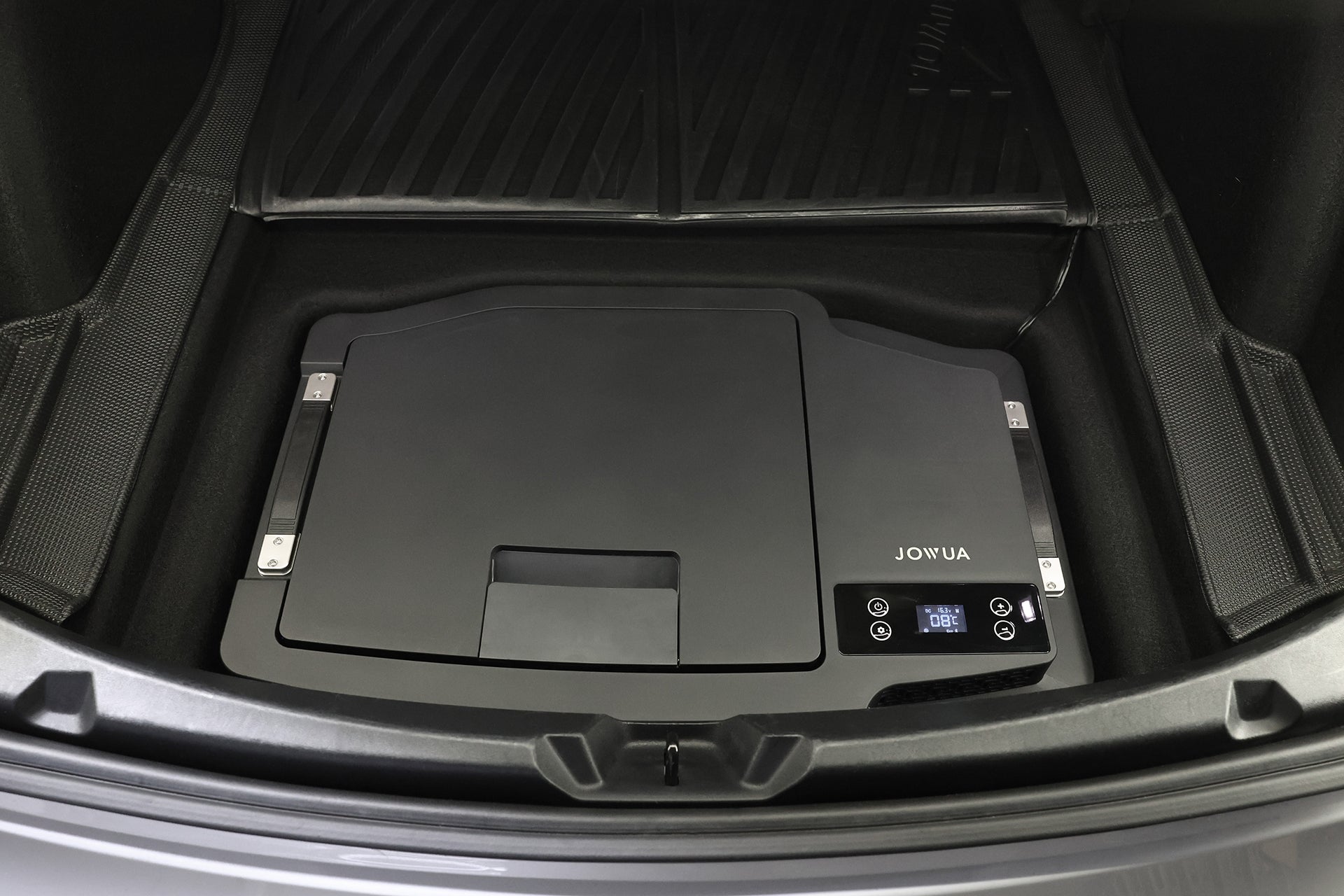 黑色的 JOWUA Taiwan Type-C 車用行動冰箱 (Model 3 全車系) 配備數位顯示和控制按鈕，置於後車廂地墊上，提供高效能供電，讓您在旅途中都能享有可靠的效能。.