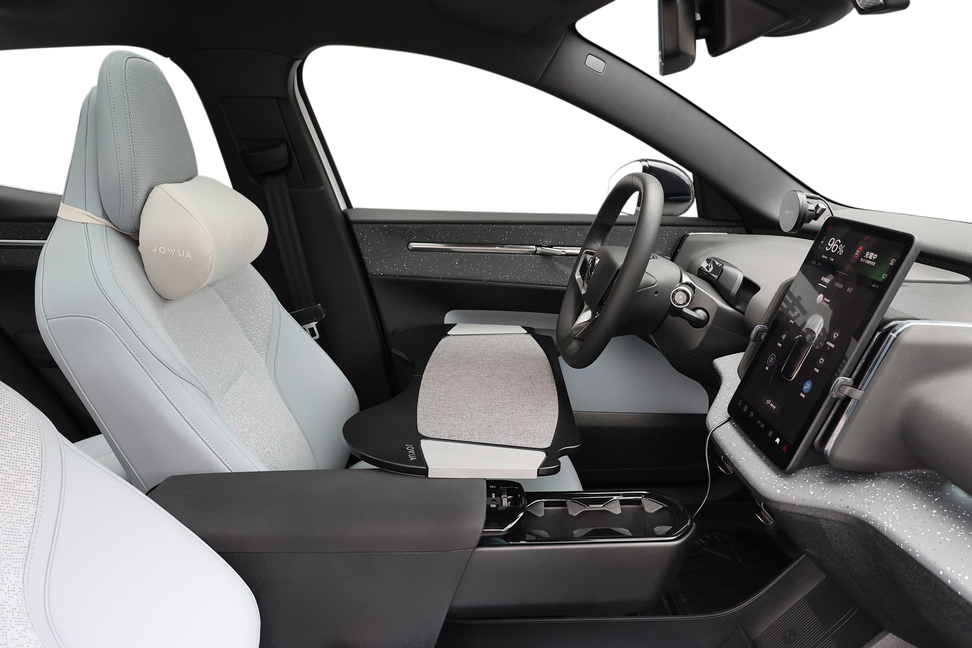 現代化車廂內，淺灰色座椅、印有 OPULIA 文字的頭枕、方便使用的 JOWUA Taiwan 車用折疊桌板、杯座，以及右側的大型觸控螢幕。.