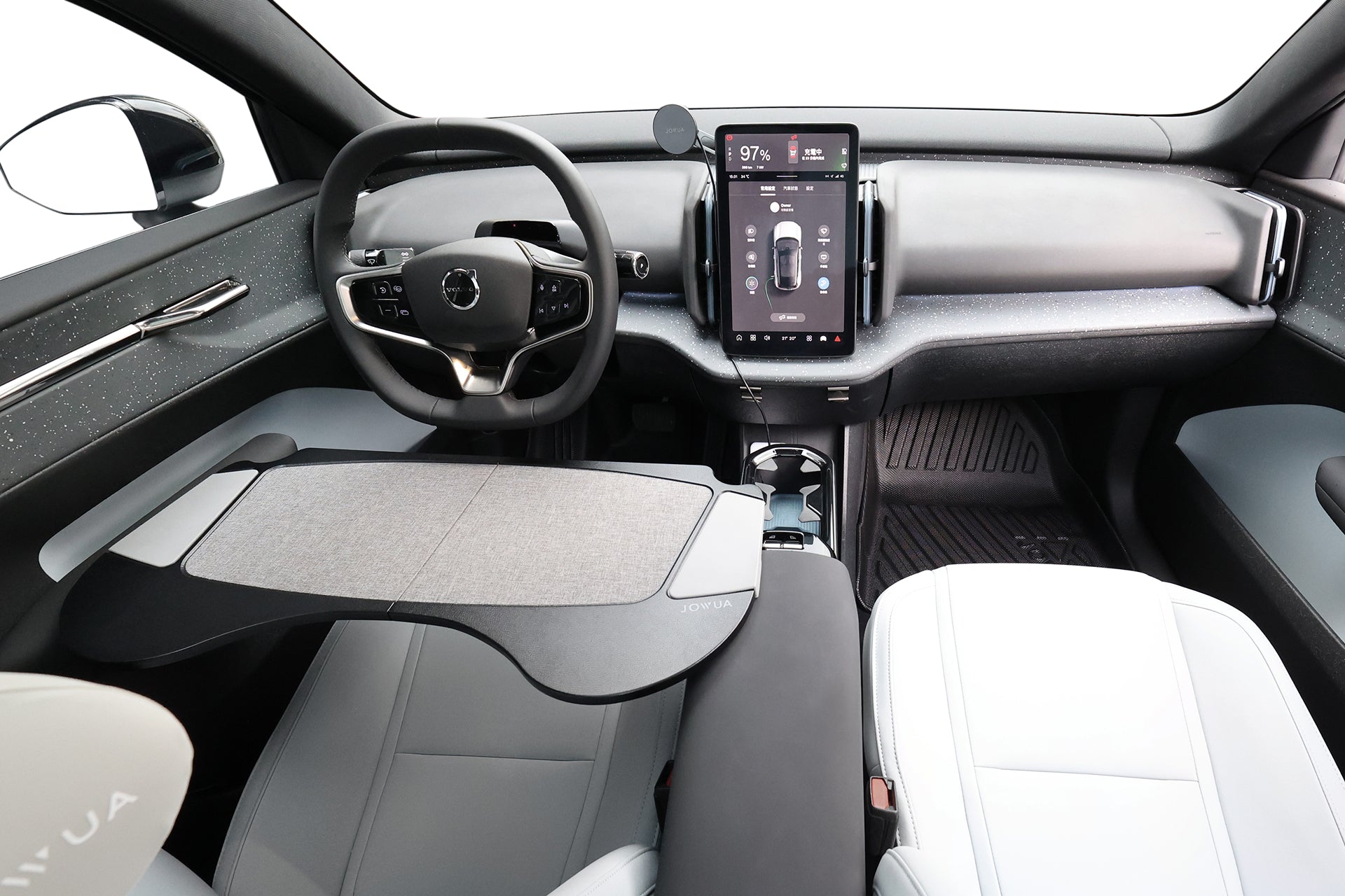 圖為現代化的汽車內裝，配備大型觸控螢幕、流線型儀表板、輕巧的座椅，以及可摺疊在副駕駛座上的 JOWUA Taiwan 車用摺疊桌板，方便使用。.
