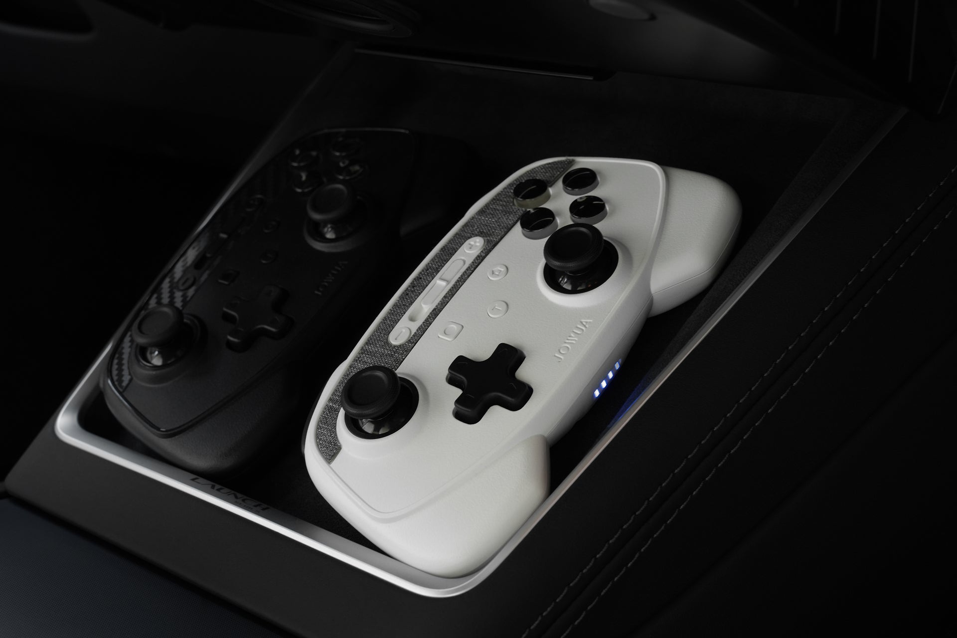 JOWUA台灣無線充電雙搖桿組合（適用於Model S/X/3/Y煥新版及Cybertruck）配備黑白控制器，支援Steam遊戲藍牙連接，並排放置在車用托盤內，帶來藍色LED燈效果。.