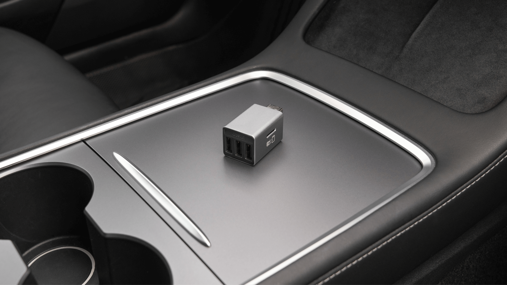 JOWUA台灣手套專用箱3埠集線器+讀卡機採用USB3抗干擾技術，位於汽車中控台上，內裝時尚現代，採用深色內裝和銀色裝飾。.